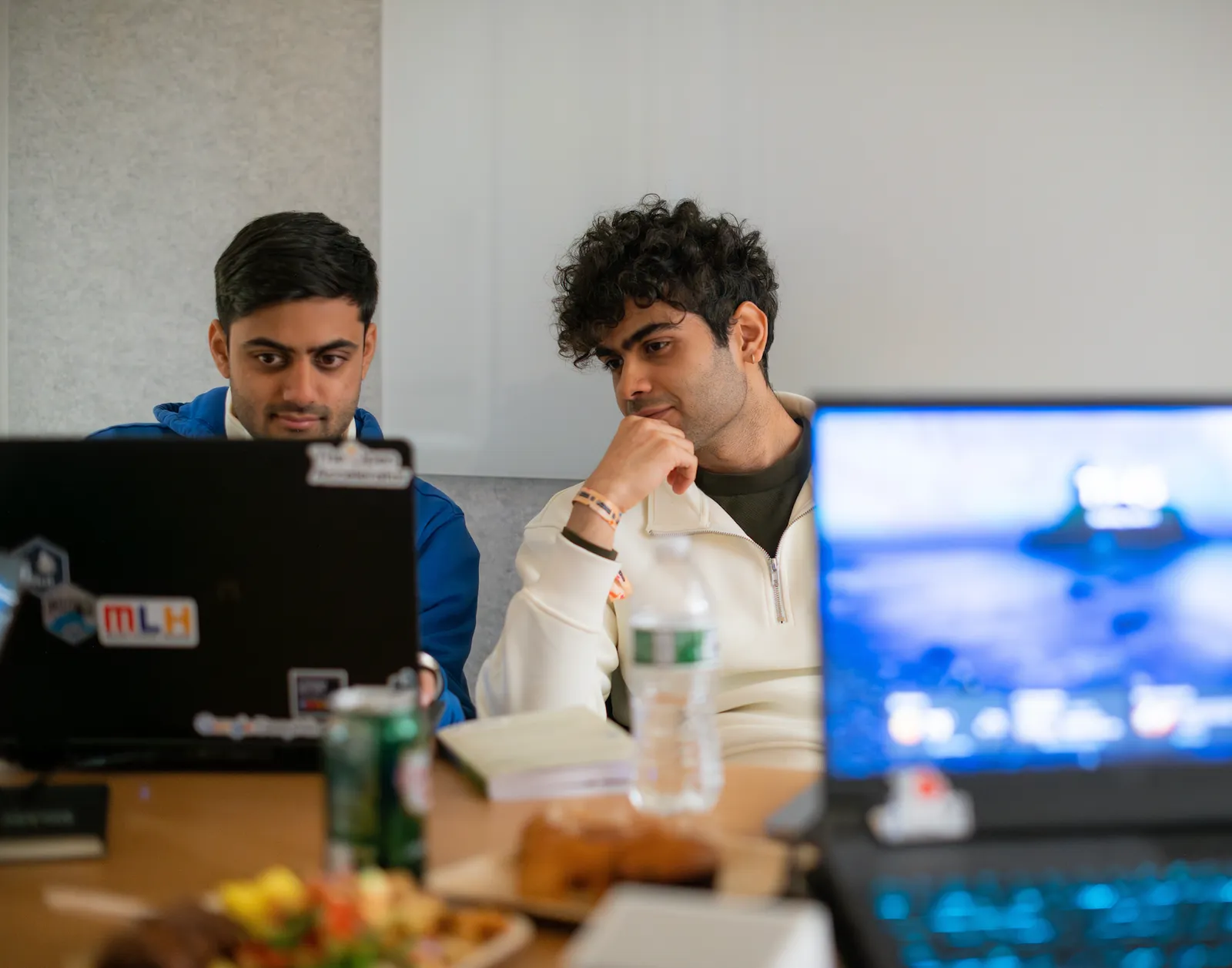 Two teammates reviewing the CashMeIfYouCan build on screen.